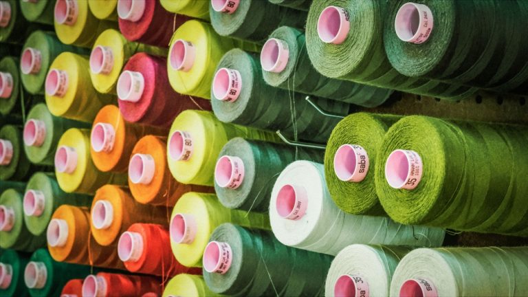 Cones of coloured thread on a mill rack.
